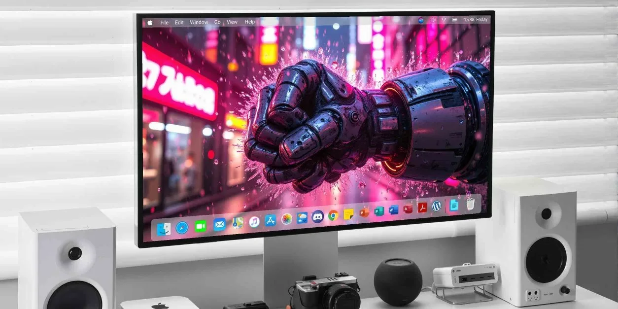 A desktop monitor displays a large metallic fist clenched in the foreground, with pink neon signs and a blurred street behind it.